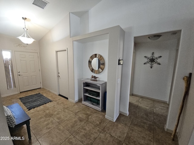 tiled entrance foyer featuring vaulted ceiling