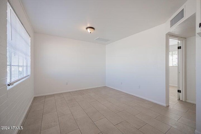 tiled empty room featuring a wealth of natural light