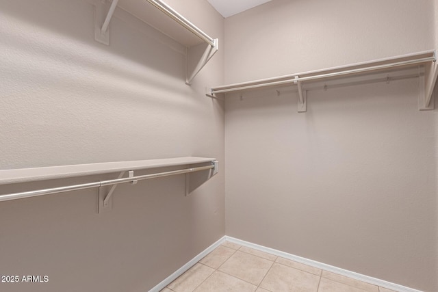 spacious closet featuring light tile patterned floors