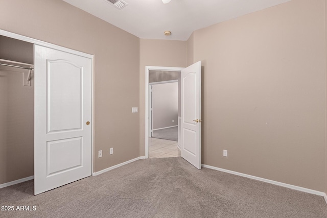 unfurnished bedroom featuring carpet, a closet, visible vents, and baseboards