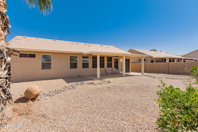 back of property with a tiled roof, a patio area, fence, and stucco siding