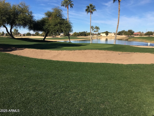 view of community featuring a water view, view of golf course, and a lawn