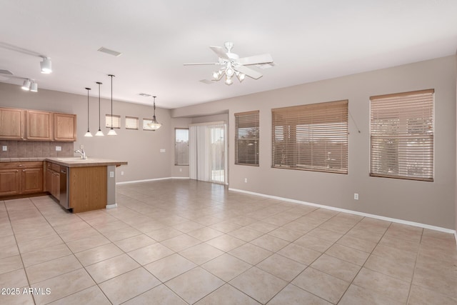 kitchen featuring light countertops, visible vents, stainless steel dishwasher, open floor plan, and a peninsula