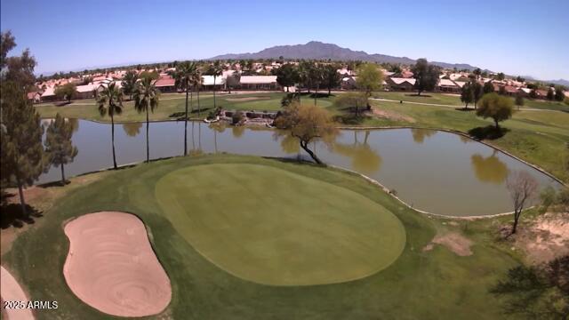 view of home's community with view of golf course and a water and mountain view