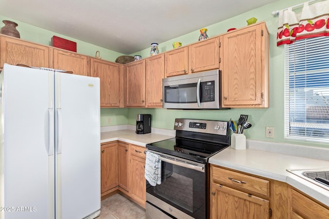 kitchen with light tile patterned floors, stainless steel appliances, and light countertops