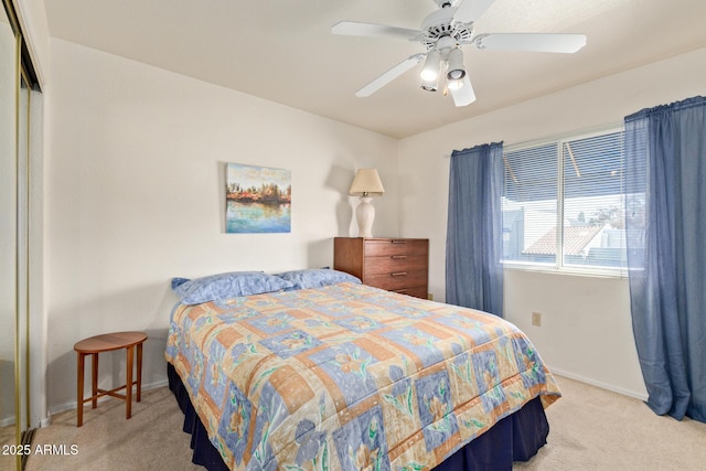 bedroom with light carpet, ceiling fan, and baseboards