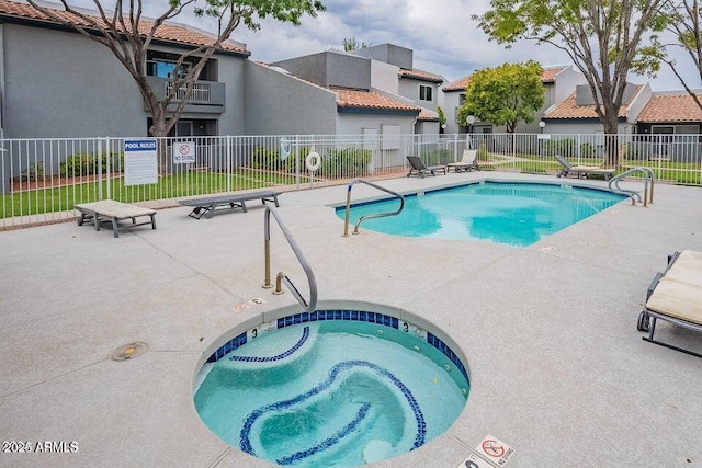 pool with a patio, fence, and a residential view