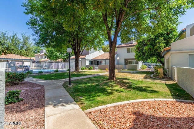 surrounding community featuring a gazebo, a swimming pool, fence, and a yard