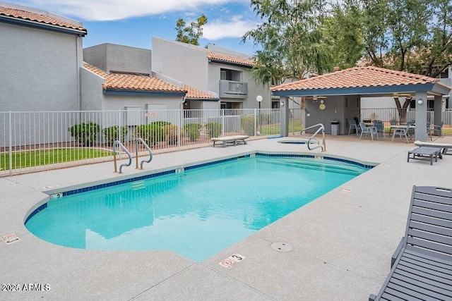 pool featuring a hot tub, fence, and a patio