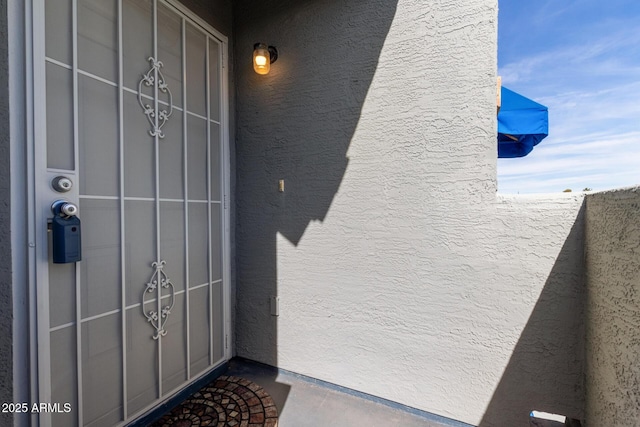 doorway to property featuring stucco siding