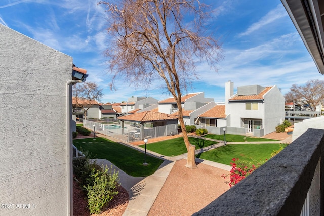 exterior space featuring a residential view, fence, and a yard