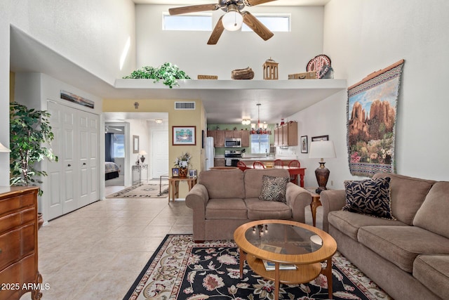 living room featuring light tile patterned floors, a high ceiling, visible vents, and a healthy amount of sunlight