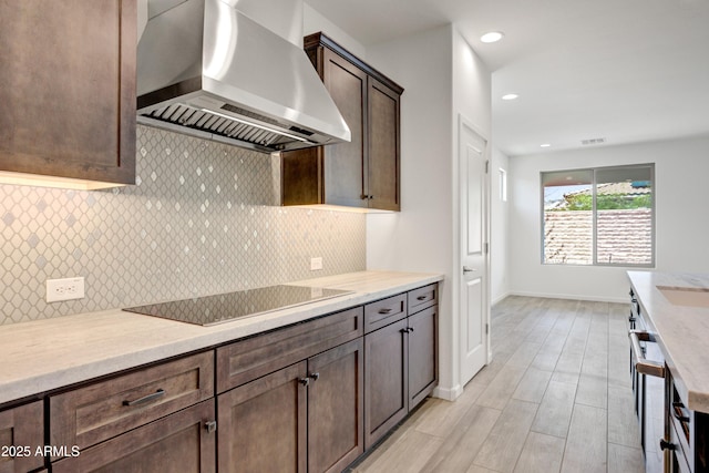 4515 Charro Ct, Wickenburg, AZ 85390 - kitchen with wall chimney exhaust hood, black electric cooktop, dark brown cabinets, backsplash, and baseboards