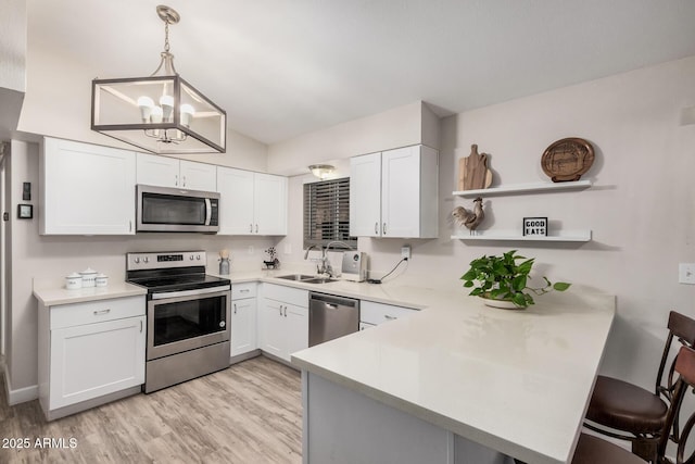 5808 E Lawndale St, Mesa, AZ 85215 - kitchen with stainless steel appliances, a sink, a peninsula, a chandelier, and open shelves