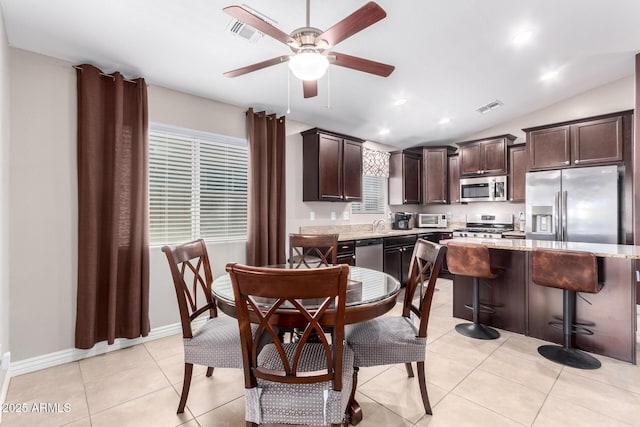 kitchen with visible vents, dark brown cabinetry, light tile patterned floors, stainless steel appliances, and a ceiling fan