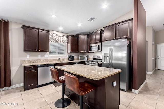 kitchen featuring dark brown cabinetry, light tile patterned floors, visible vents, and stainless steel appliances