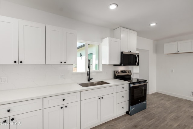 kitchen featuring a sink, white cabinetry, light countertops, appliances with stainless steel finishes, and tasteful backsplash