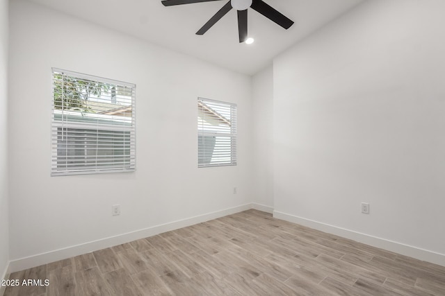 empty room featuring light wood finished floors, a wealth of natural light, and ceiling fan