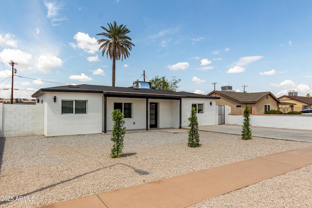 ranch-style house with stucco siding, fence, and a patio