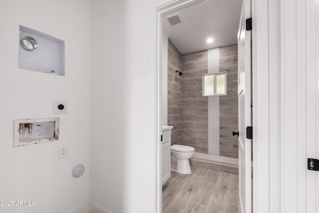 bathroom featuring toilet, wood finished floors, visible vents, recessed lighting, and a shower stall