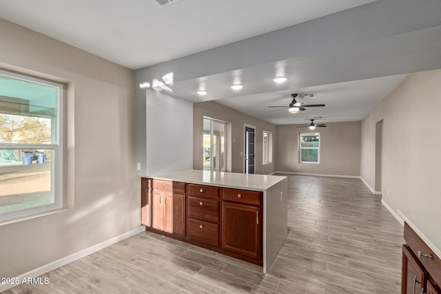 kitchen featuring ceiling fan, kitchen peninsula, and light hardwood / wood-style flooring