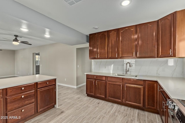 kitchen with sink, decorative backsplash, light hardwood / wood-style flooring, and stainless steel electric stove