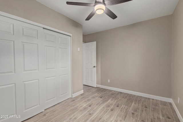 unfurnished bedroom with ceiling fan, a closet, and light wood-type flooring