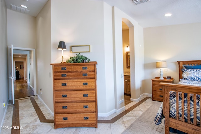 3441 N 162nd Ln, Goodyear, AZ 85395 - bedroom with arched walkways, baseboards, recessed lighting, inlaid floor details, and connected bathroom