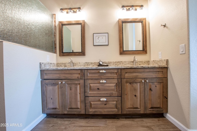 3441 N 162nd Ln, Goodyear, AZ 85395 - bathroom with double vanity, baseboards, and wood finished floors