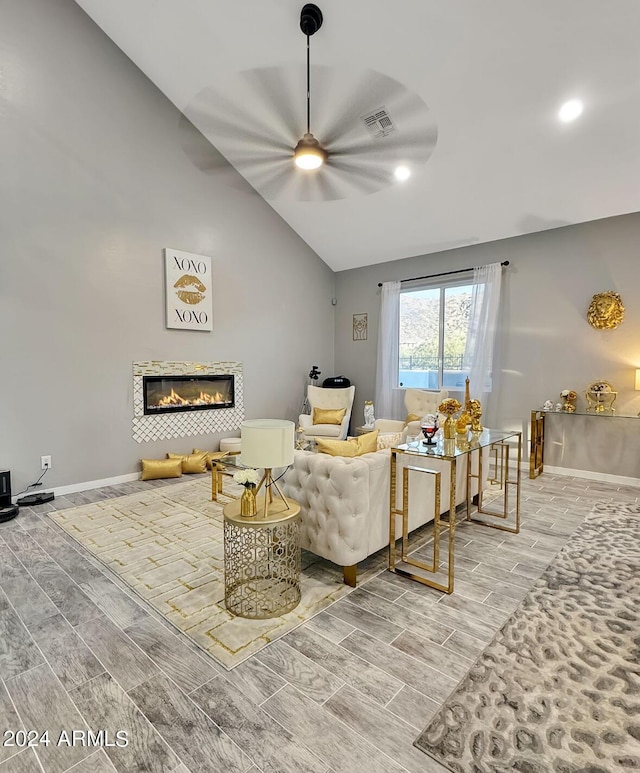 living room with ceiling fan, wood-type flooring, and lofted ceiling