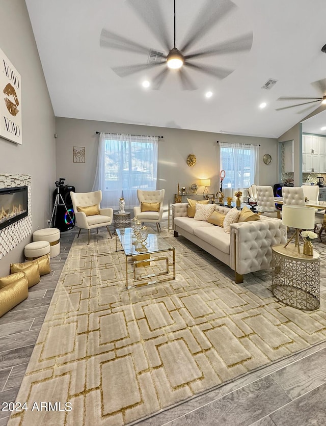 living room featuring ceiling fan, a healthy amount of sunlight, lofted ceiling, and light hardwood / wood-style floors