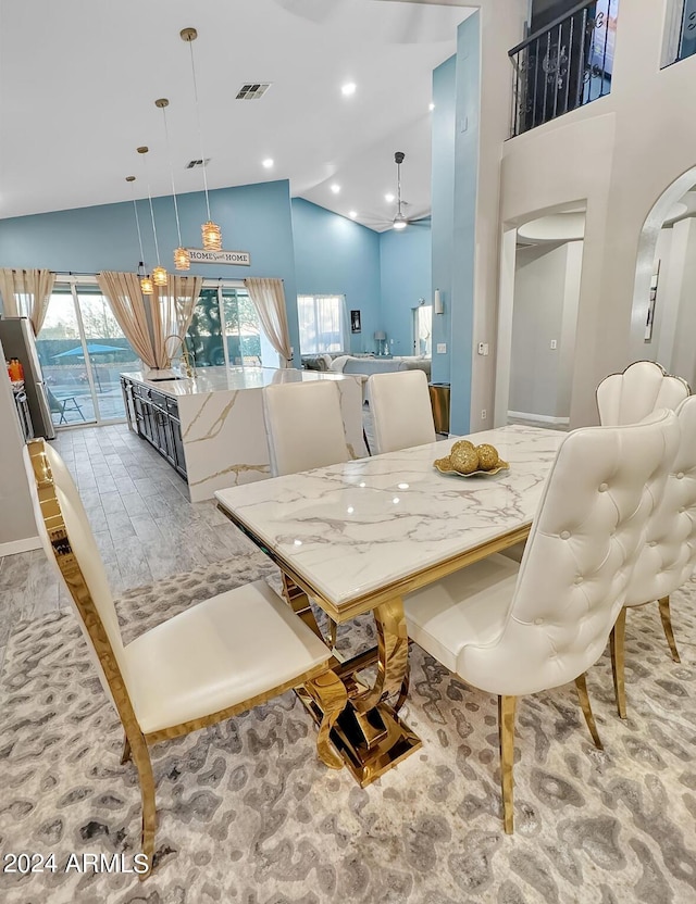 dining room featuring ceiling fan and high vaulted ceiling