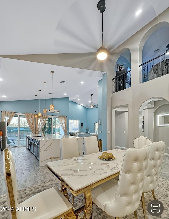 dining space with wood-type flooring, vaulted ceiling, and ceiling fan