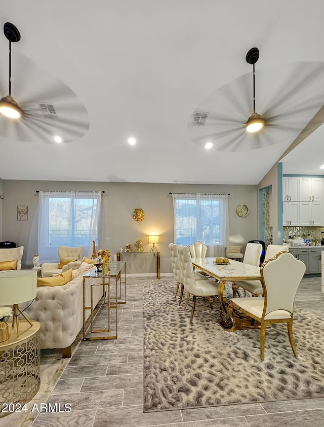 dining space with a wealth of natural light, lofted ceiling, and ceiling fan