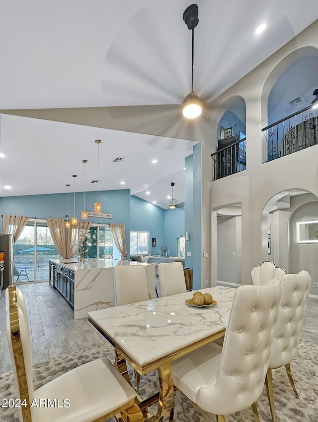 dining space featuring ceiling fan, hardwood / wood-style floors, and vaulted ceiling