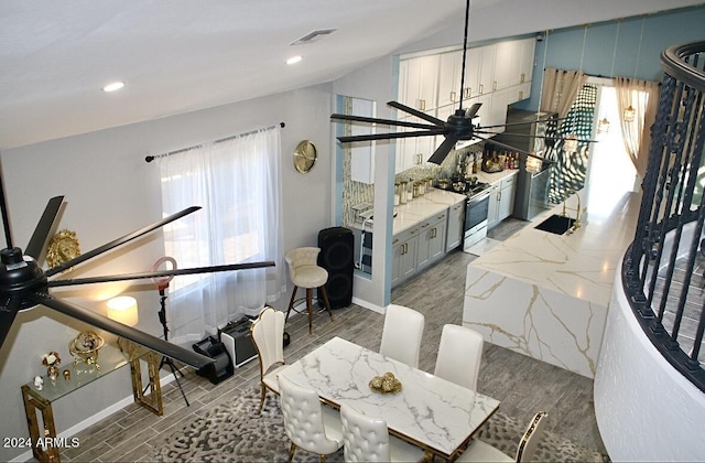 dining space featuring hardwood / wood-style floors, ceiling fan, and lofted ceiling