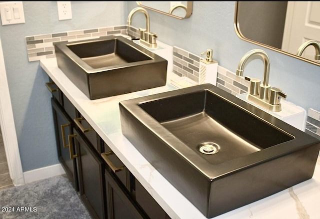 details featuring tasteful backsplash and sink