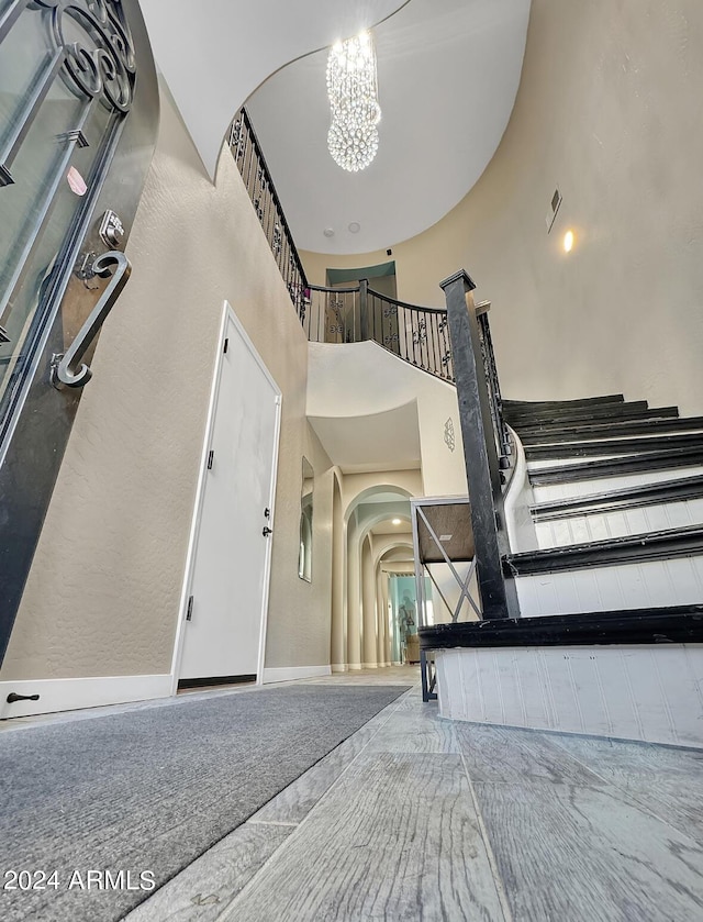 stairs featuring a notable chandelier and a high ceiling