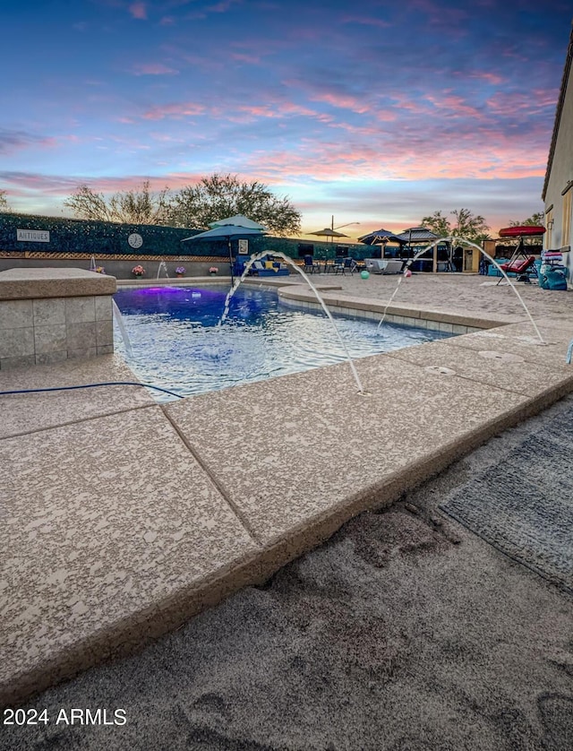 pool at dusk with pool water feature