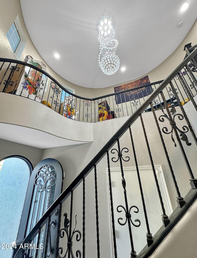 stairway featuring a chandelier