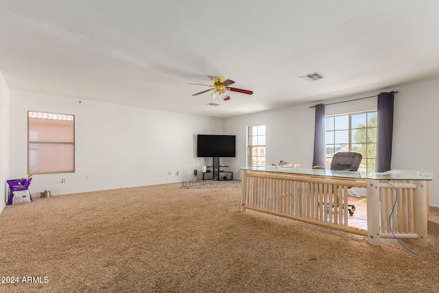 unfurnished living room with carpet flooring and ceiling fan