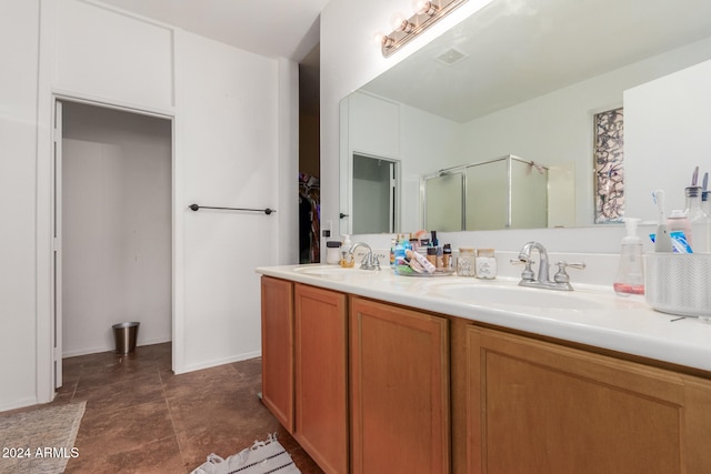 bathroom featuring tile patterned flooring, vanity, and an enclosed shower