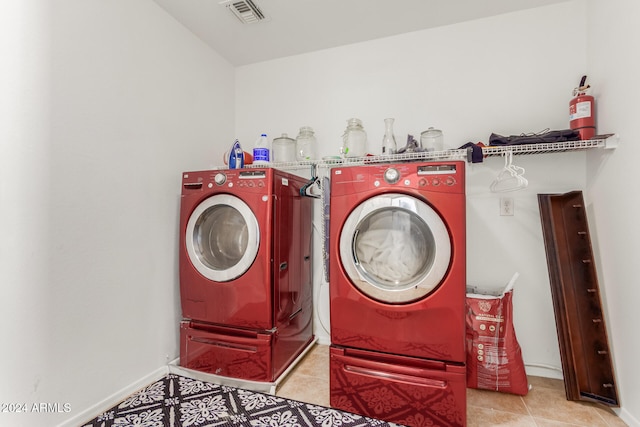 washroom with washer and clothes dryer and light tile patterned floors