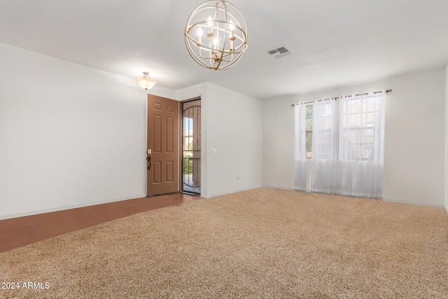 unfurnished room featuring a chandelier