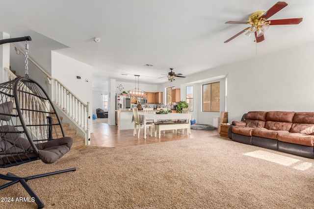 living room with carpet, ceiling fan with notable chandelier, and plenty of natural light