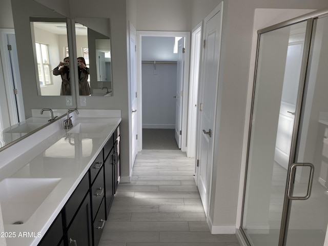 bathroom featuring hardwood / wood-style floors, vanity, and walk in shower