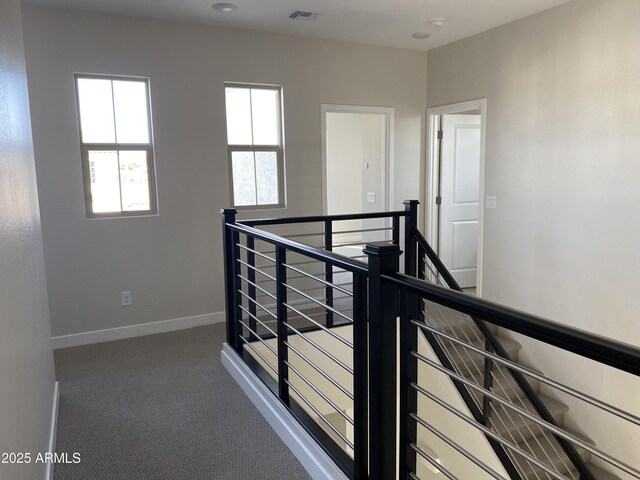 hallway featuring dark colored carpet