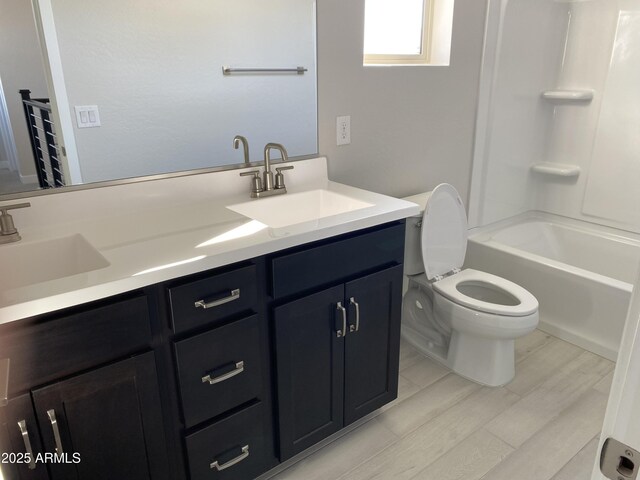 full bathroom with washtub / shower combination, hardwood / wood-style flooring, vanity, and toilet