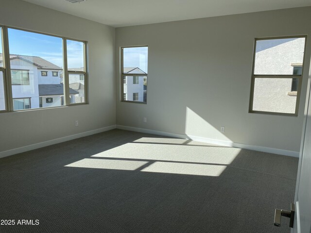 unfurnished room with dark colored carpet