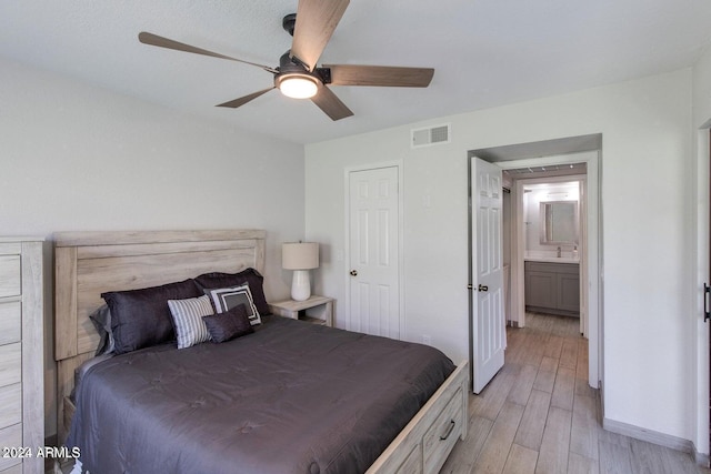 bedroom with sink, ensuite bathroom, ceiling fan, and light wood-type flooring